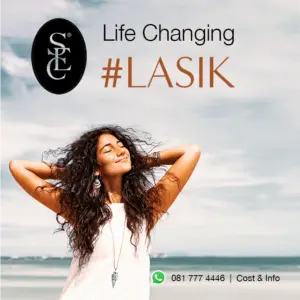 A beautiful woman standing on a beach with the wind gently blowing through her hair, symbolising the life-changing effect of LASIK